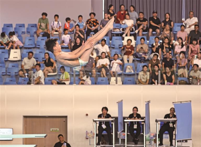 7月28日，省十八运会青少年组跳水项目比赛现场，选手在空中完成翻转动作。
